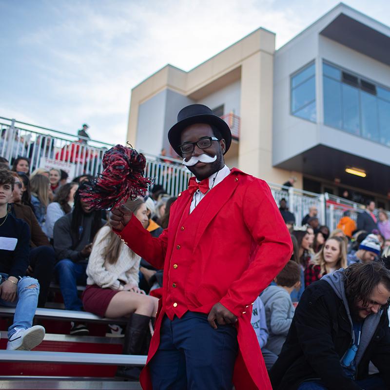 学生打扮成政府官员在足球场摆姿势拍照